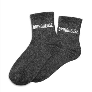 Une paire de chaussettes courtes en coton, parsemées de paillettes scintillantes. L'inscription "Bringueuse" est brodée en blanc sur le dessus de chaque chaussette.