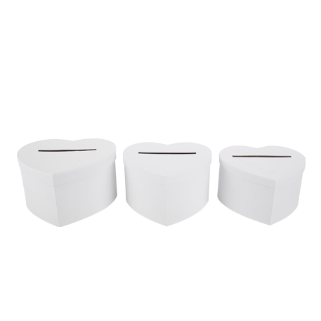 Une urne en forme de cœur blanc, posée sur une table décorée de fleurs blanches et de bougies. L'urne est mise en valeur par un éclairage doux.