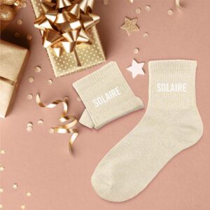 chaussettes couleur sable à paillettes avec la mention Solaire en blanc