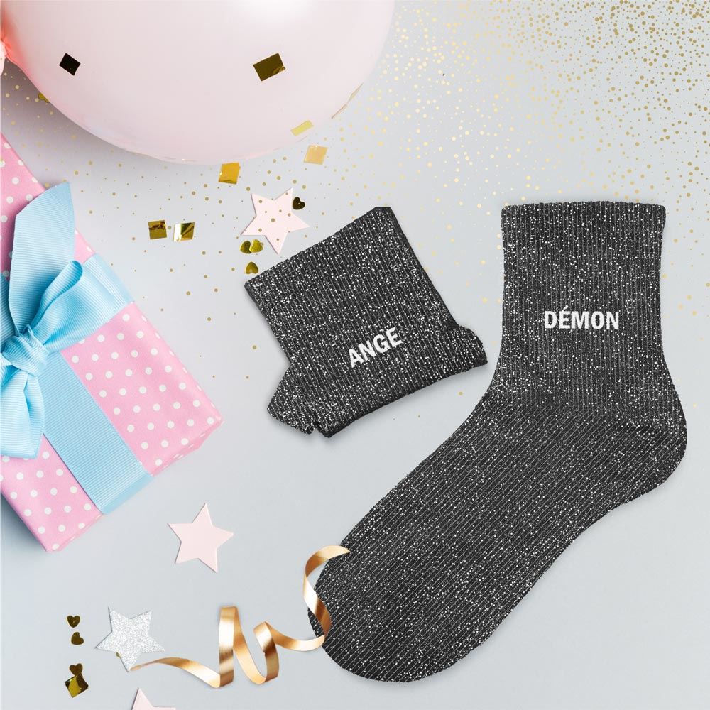 chaussettes dépareillées noires à paillettes avec les mentions Ange et Démon en blanc .
