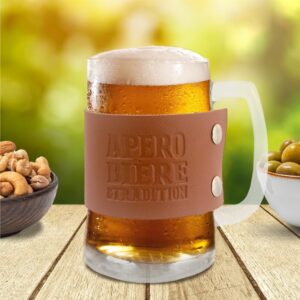 Pour les amateurs et amatrices de bières, et ceux qui apprécient les traditions des moments partagés, notre chope de bière est faite pour vous ! Reprenant la forme classique d'une chope transparente, elle est sublimée par un élégant morceau de cuir (ou simili-cuir) marron sur lequel est joliment embossée la mention "Apéro Bière & Tradition". Ce verre vous sera indispensable pour savourer votre bière préférée lors de moments conviviaux entre amis ou en famille.