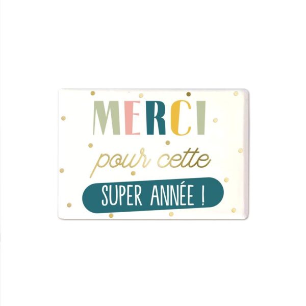 Original et attendrissant, ce magnet "Merci pour cette super année !" est par excellence l’objet décoratif qui fera fondre le cœur de tout enseignant et enseignante ! Aimanté et de forme rectangulaire, il présente un fond blanc à points dorés ainsi que la mention multicolore "Merci pour cette super année !", offrant un cadeau mémorable et plein de gratitude.