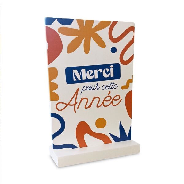 Remerciez votre enseignant(e) pour l'année scolaire écoulée avec un cadeau unique et mémorable : notre plaque à poser en bois "Merci pour cette année". Cette décoration pratique et affective, avec son design coloré et sa mention chaleureuse, est idéale pour apporter une touche de gratitude et de gaieté à son espace de travail.