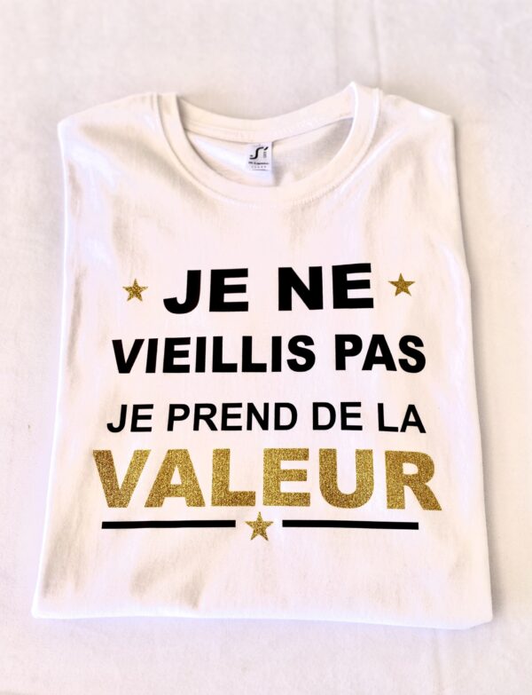 Parce que l'âge n'est qu'un chiffre, et l'expérience un trésor ! Notre T-shirt Blanc Homme "Je ne vieillis pas je prends de la valeur" est la manière parfaite de célébrer le temps qui passe avec une bonne dose d'optimisme et d'humour. Ce t-shirt affiche fièrement un message qui saura faire sourire et rappeler avec légèreté que chaque année est un millésime qui affine le caractère, comme un bon vin ou un objet de collection !