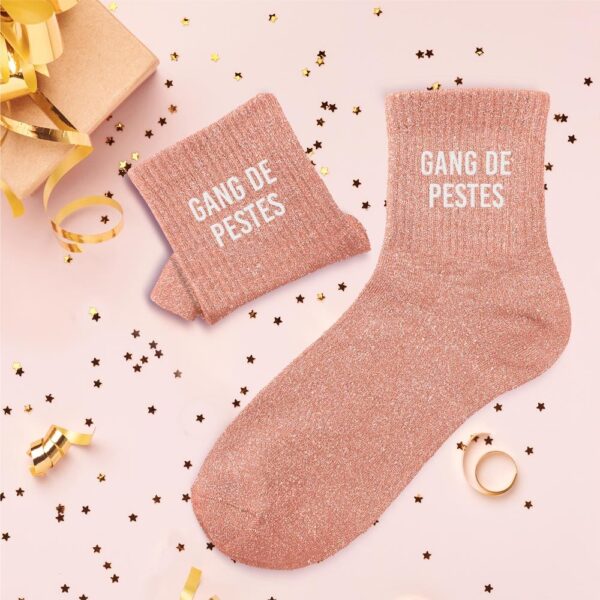 À la recherche d'une paire de chaussettes originale scintillante pour vous et vos meilleures amies ? Notre paire de chaussettes à paillettes "Gang de Pestes" est l'accessoire Mode idéal ! Avec leur couleur rose poudré étincelante et la mention "GANG DE PESTES" inscrite en blanc, elles sont la garantie d'un look stylé tout en affichant un message amusant et complice. Elles sont parfaites pour les groupes d'amies inséparables qui aiment rire d'elles-mêmes et partager des moments décalés.