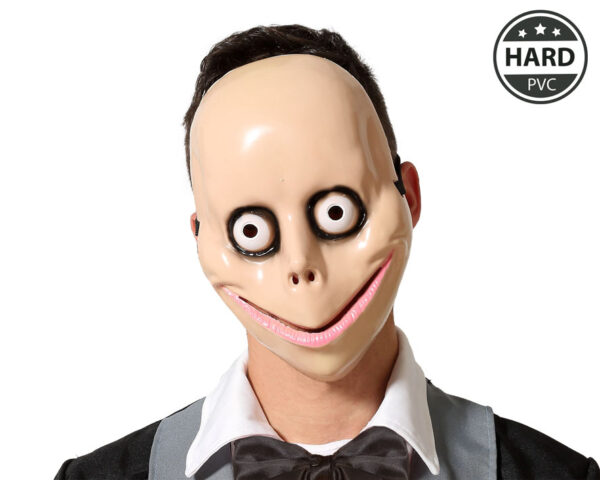 Un masque d'horreur en PVC de couleur beige, inspiré du personnage de Momo. Le masque a des yeux ronds et exorbités, une bouche en large sourire avec un contour rose, et des traits fins peints en noir.