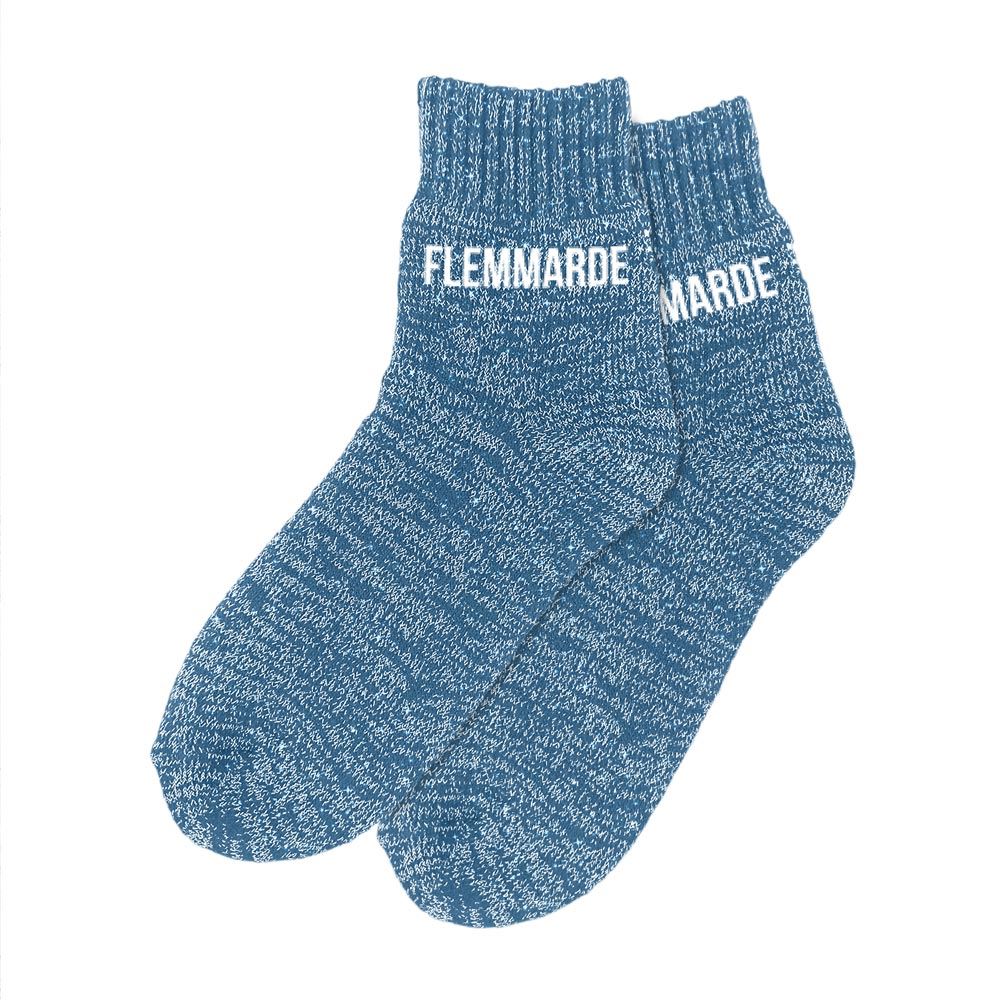 Paire de chaussettes polaires épaisses de couleur bleu chiné pailleté, avec le mot "FLEMMARDE" imprimé en blanc sur les deux pieds.