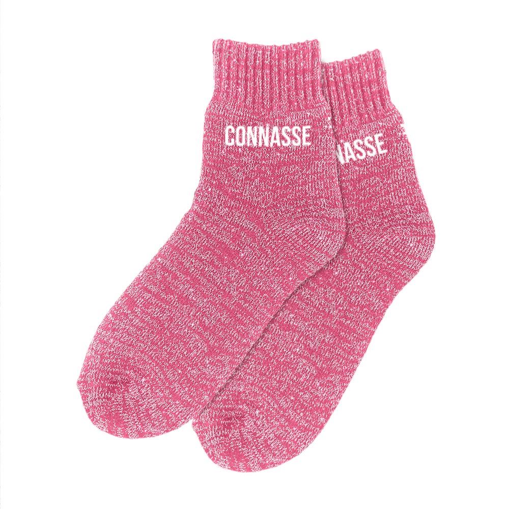 Paire de chaussettes polaires épaisses de couleur rose chiné pailleté, avec le mot "CONNASSE" imprimé en blanc sur les deux pieds.