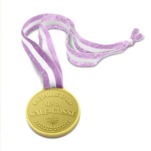 Médaille dorée humoristique avec l'inscription "Médaille d'or de l'Emmerdeuse", décorée de cœurs et de lauriers, suspendue à un ruban blanc et or pailleté.