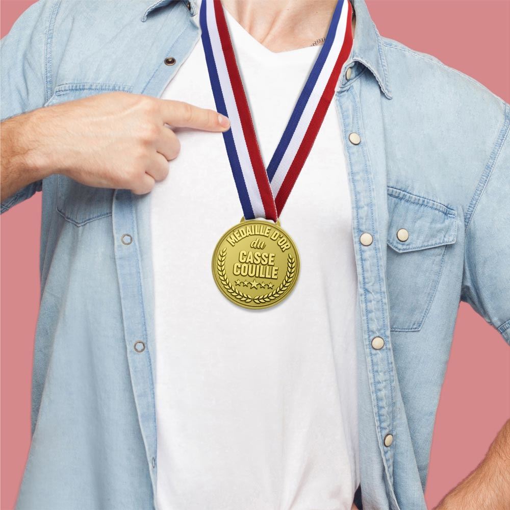 Médaille d'or fantaisie avec un ruban tricolore, gravée avec l'inscription humoristique "MÉDAILLE D'OR du CASSE COUILLE".
