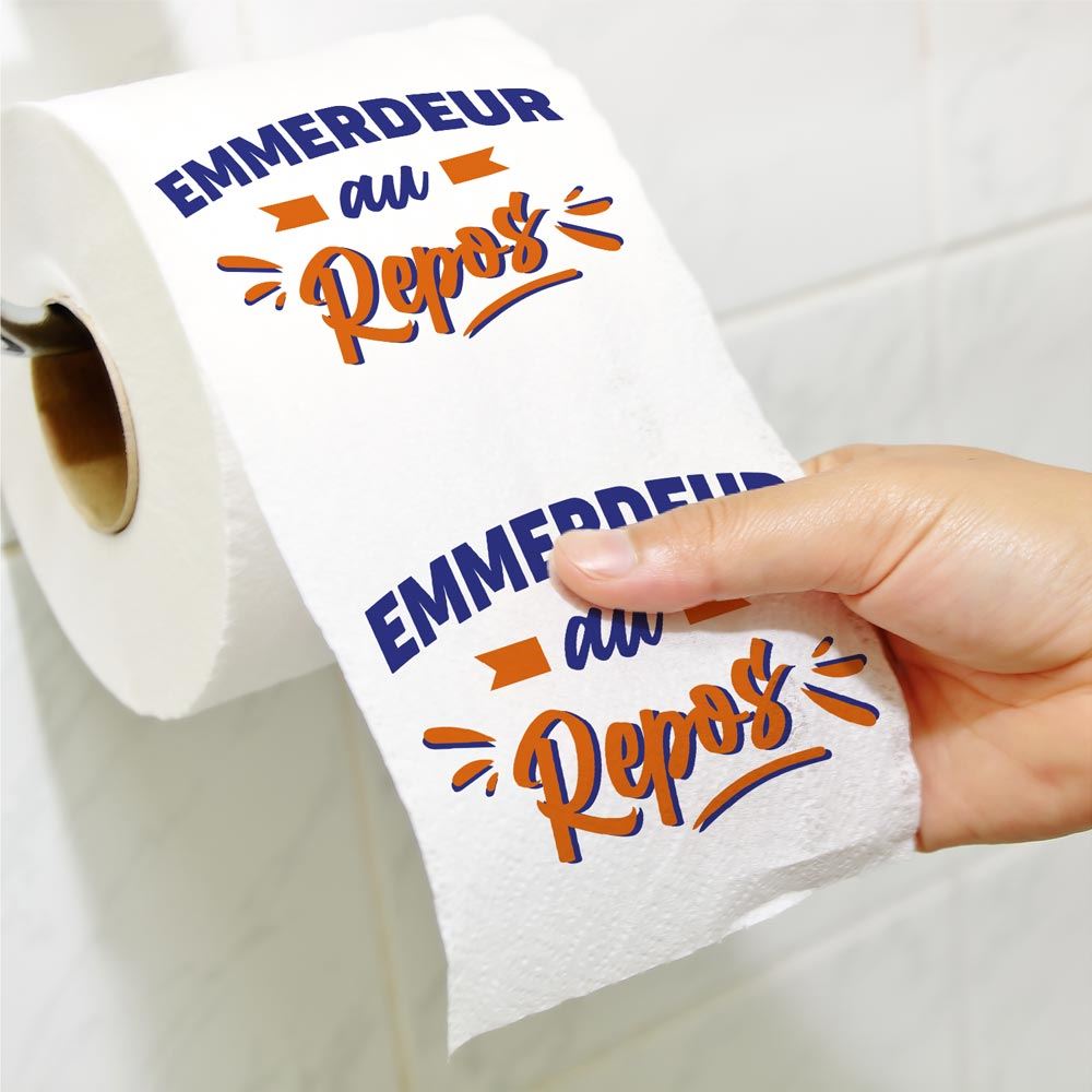 Rouleau de papier toilette blanc avec le message humoristique "EMMERDEUR au Repos" imprimé en bleu et orange.