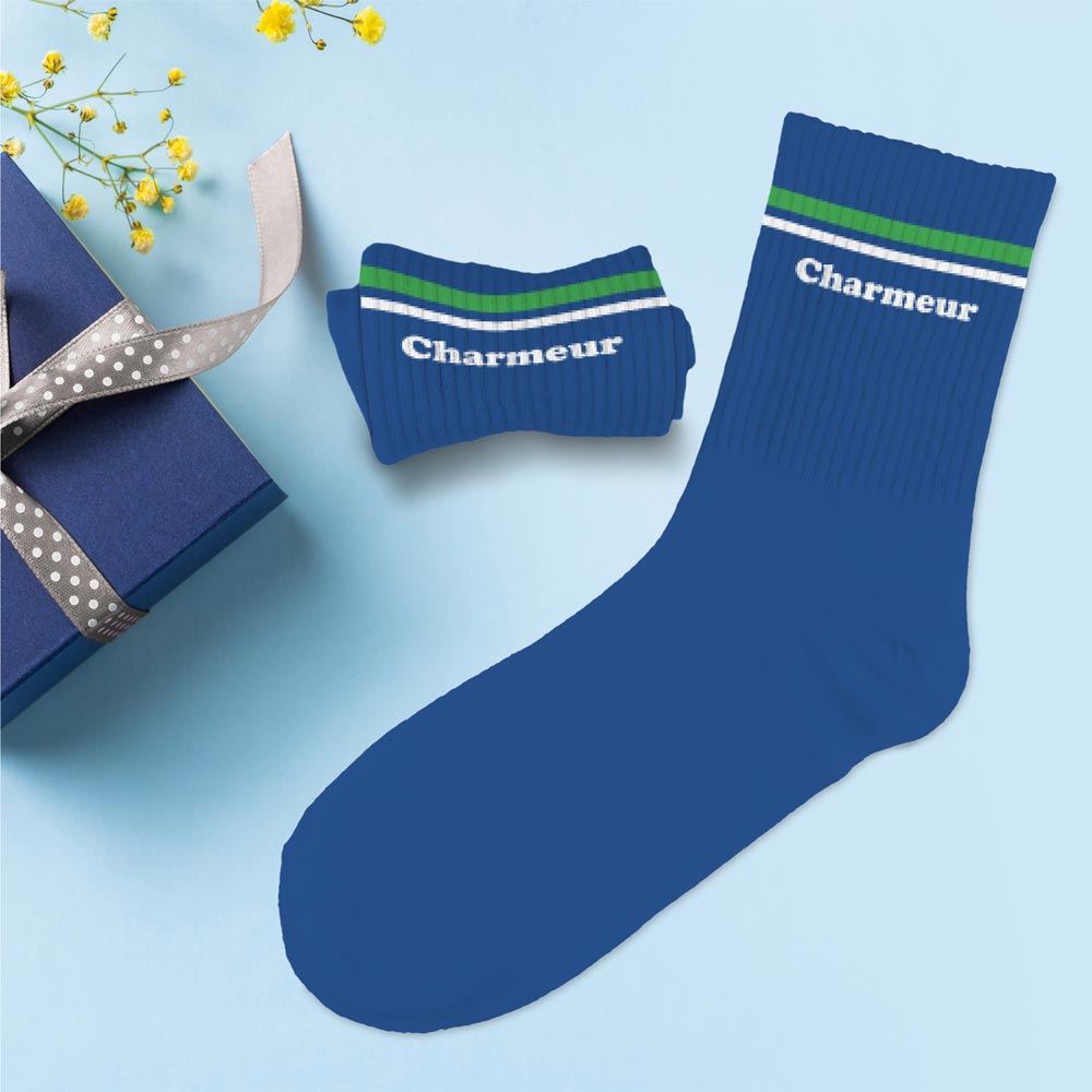 Paire de chaussettes hautes bleues pour homme avec l'inscription "Charmeur" en blanc et des rayures vertes et blanches sur le haut,