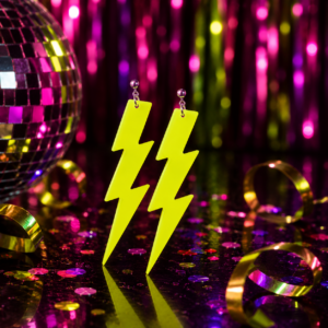 Électrisez votre style avec les boucles d'oreilles pendantes "Flash" ! Un design d'éclair néon XXL parfait pour une soirée disco ou années 80. Choix du coloris en magasin.