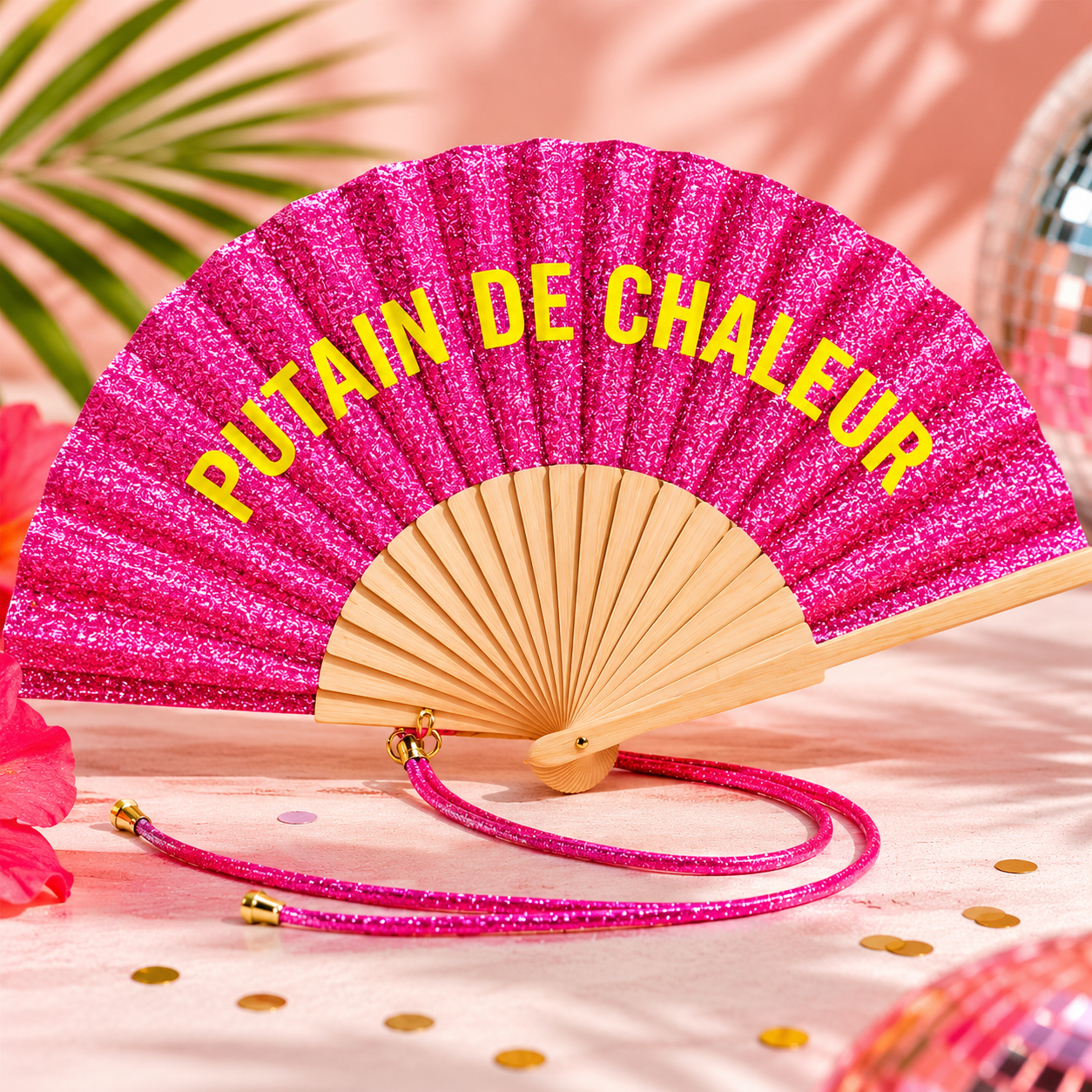 Une sélection de huit éventails colorés et pailletés ouverts, chacun doté d'une structure en bois naturel et d'un cordon de poignet scintillant assorti. Chaque éventail affiche un texte blanc ou coloré au centre : "PUTAIN DE CHALEUR" (rose), "PUTAIN J'ÉTOUFFE" (orange), "D'AMOUR ET DE PAILLETTES" (bleu), "Qué calor !" (rouge), "L'AMOUR DANS L'AIR" (rose clair), "Libre comme l'air" (violet), "La Dolce Vita" (gris argenté) et "Besoin de fraîcheur" (vert doré).