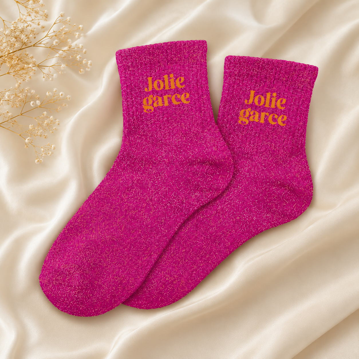 Osez l'originalité avec les chaussettes paillettes "Jolie Garce" ! Un design rose fuchsia et or scintillant avec message brodé, idéal pour un cadeau fun et stylé entre copines.