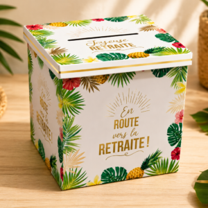 Une urne cubique en carton blanc pour célébrer un départ à la retraite. Elle est décorée de motifs tropicaux colorés : feuilles de palmier vertes, ananas jaunes et fleurs d'hibiscus roses et rouges. Sur les faces, l'inscription "En route vers la RETRAITE !" est écrite en lettres dorées et marron. Le couvercle dispose d'une fente et de l'inscription "Joyeuse RETRAITE"