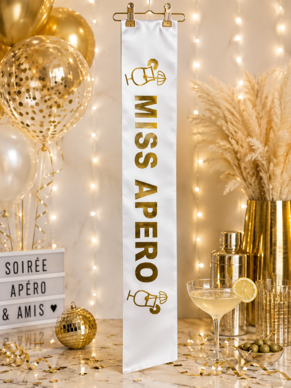 Écharpe Miss Apéro blanche et or, réalisée sur place chez Planet Fiesta. Un accessoire chic et amusant pour anniversaire, EVJF et soirée festive.